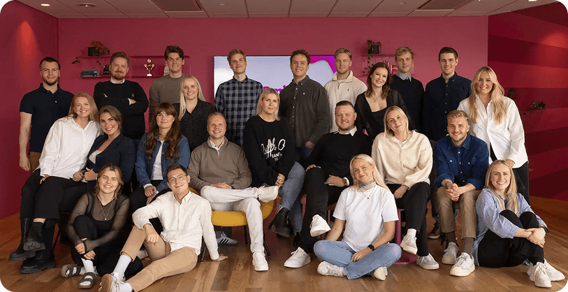 The whole Smitten team gathered in three rows against the pink office wall